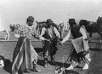 Dramatization of a fight between gauchos. Notice the ponchos wrapped 
